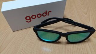白地に赤い文字色でgoodrと書かれている箱と緑色のレンズのサングラス