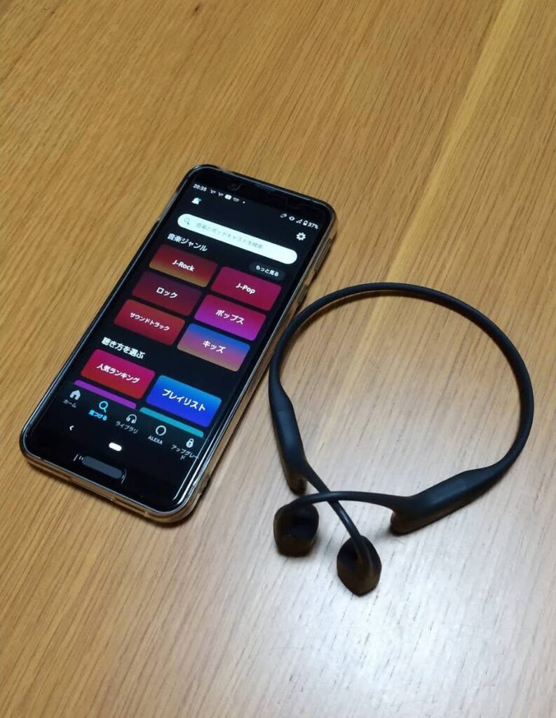 Amazon musicの音楽ジャンル選択画面が写っているスマートフォンと、Aeropexを並べた写真