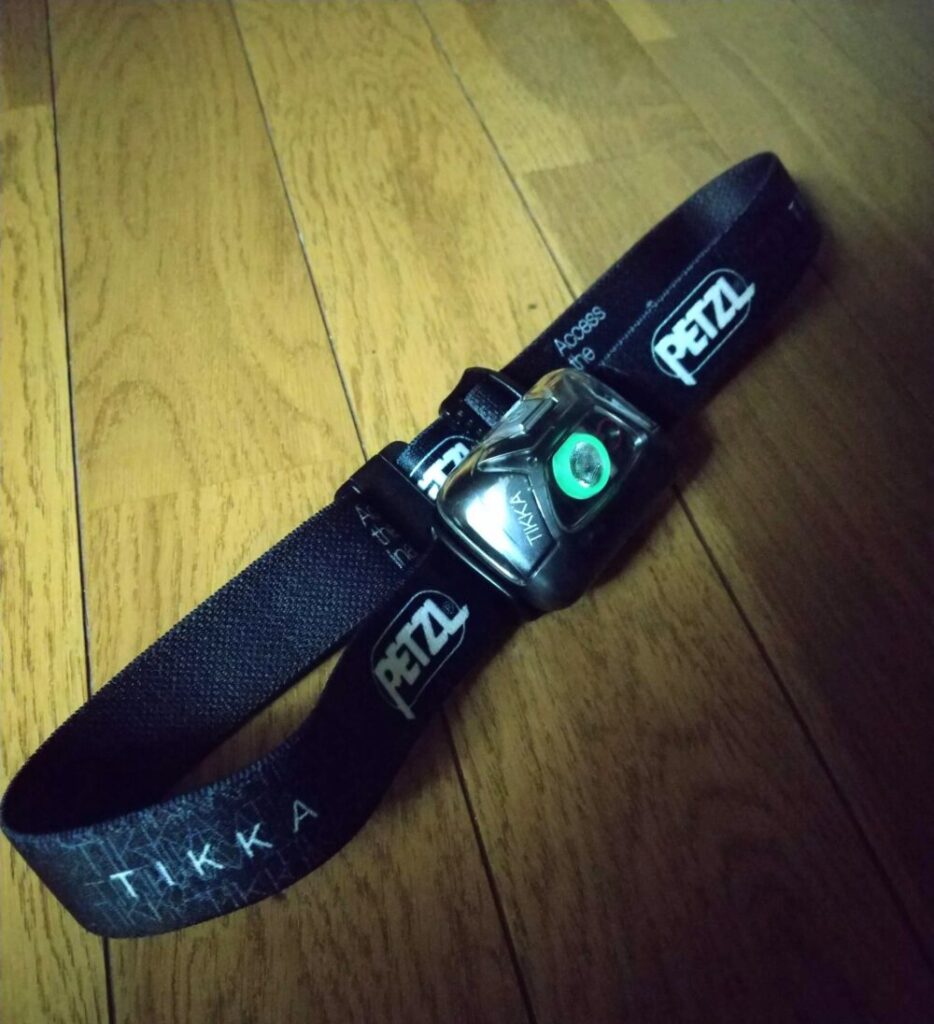 PETZL（ペツル）のヘッドライト「ティカ（黒）」に備わる蓄光リフレクターが光っている状態の写真