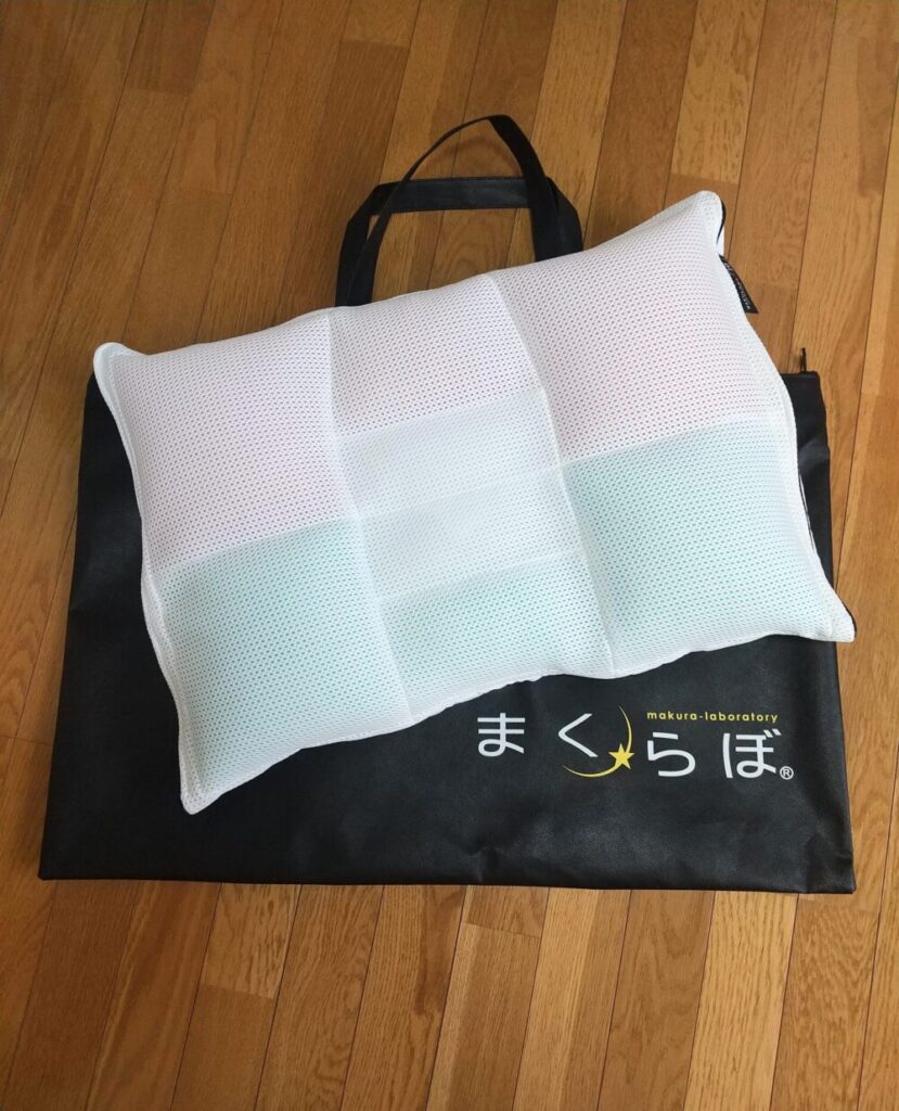 まくらぼのオーダーメイド枕レギュラーを専用の手提げ袋のうえに置いた写真