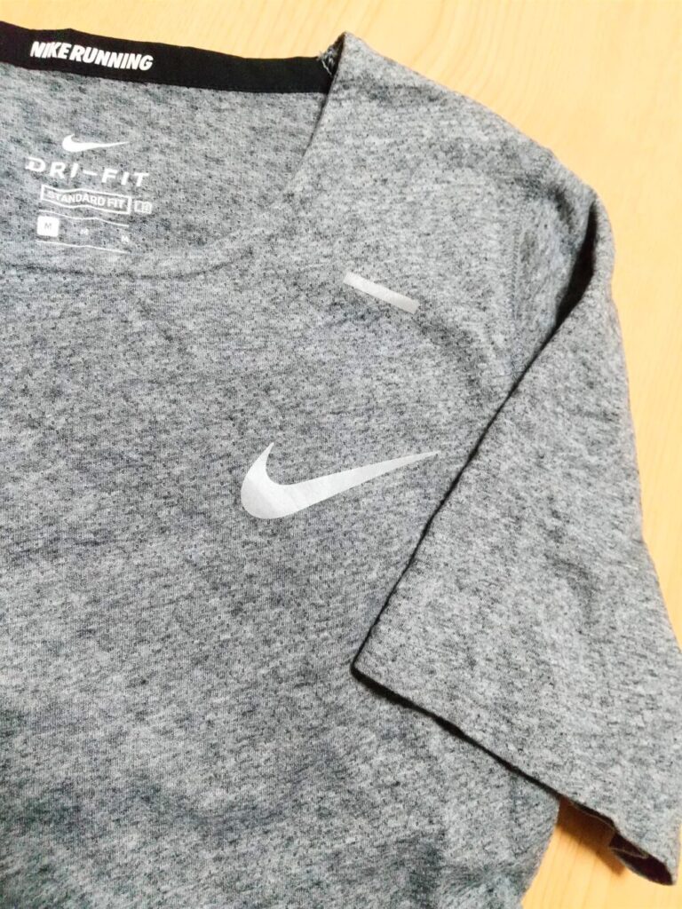 ナイキのロゴが付いたグレーのランニングTシャツを床に置いた写真