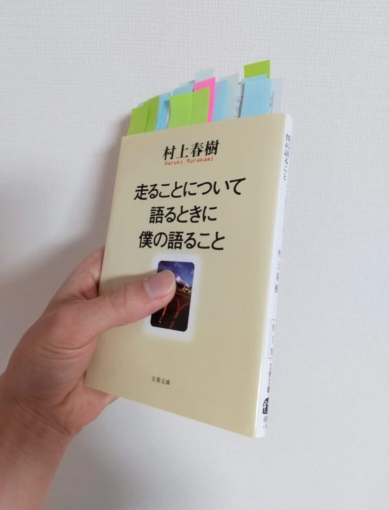 村上春樹の作品「走ることについて語るときに僕の語ること」の書籍を手に持っている写真