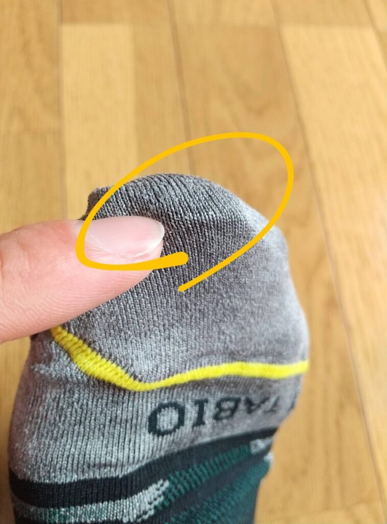 タビオの「レーシングラン・ナノグリップ（R）3D」（ブラック）の指先部分に黄色い丸をつけた画像